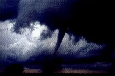 A tornado reaching down from dark storm clouds.