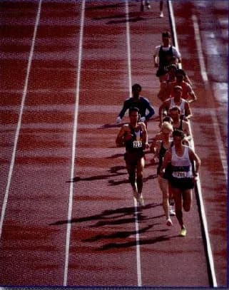 A group of runners on a running track in a race.