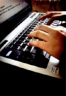 Hands typing on a laptop keyboard.
